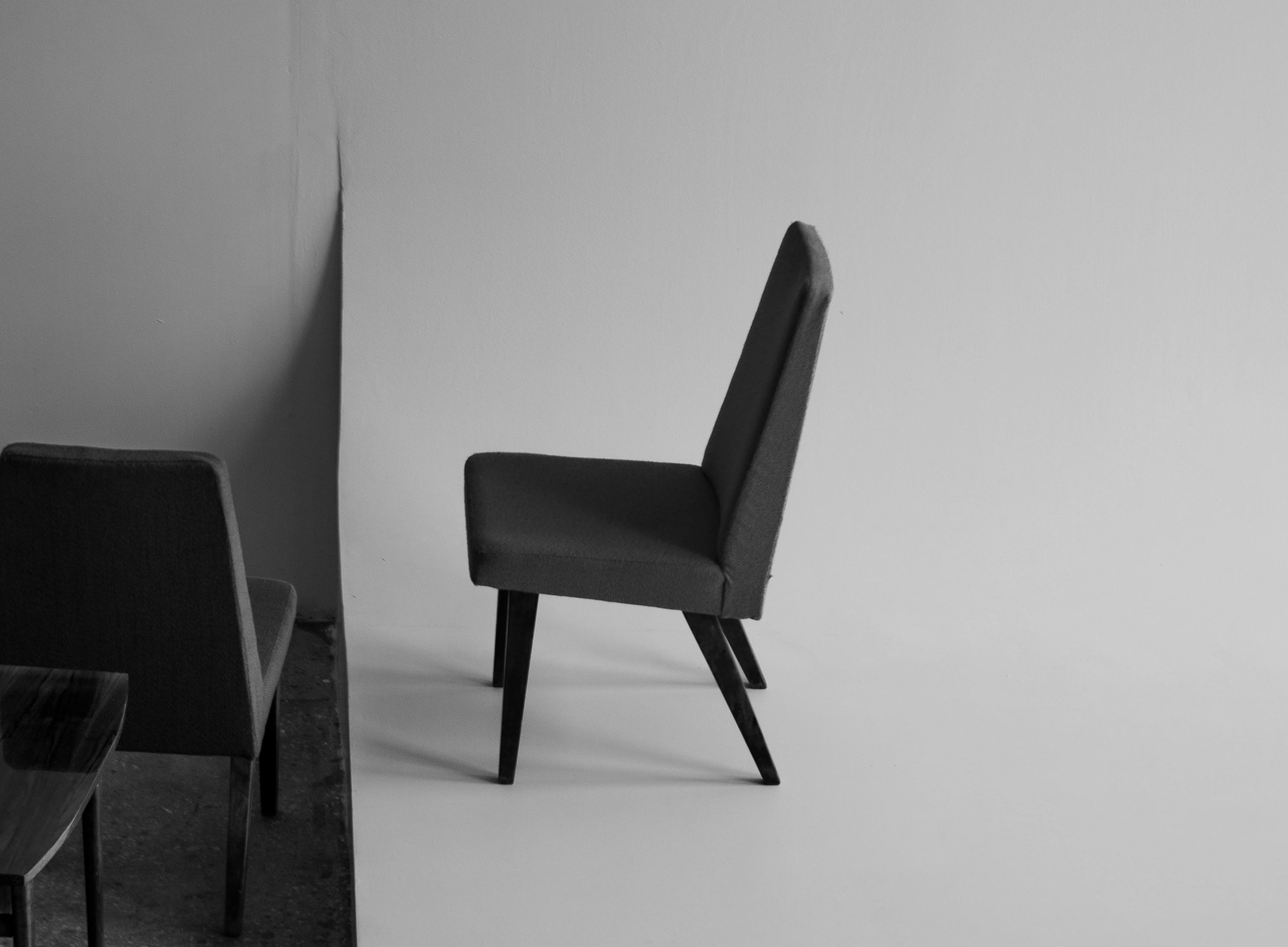 Black chair placed against a light wall.