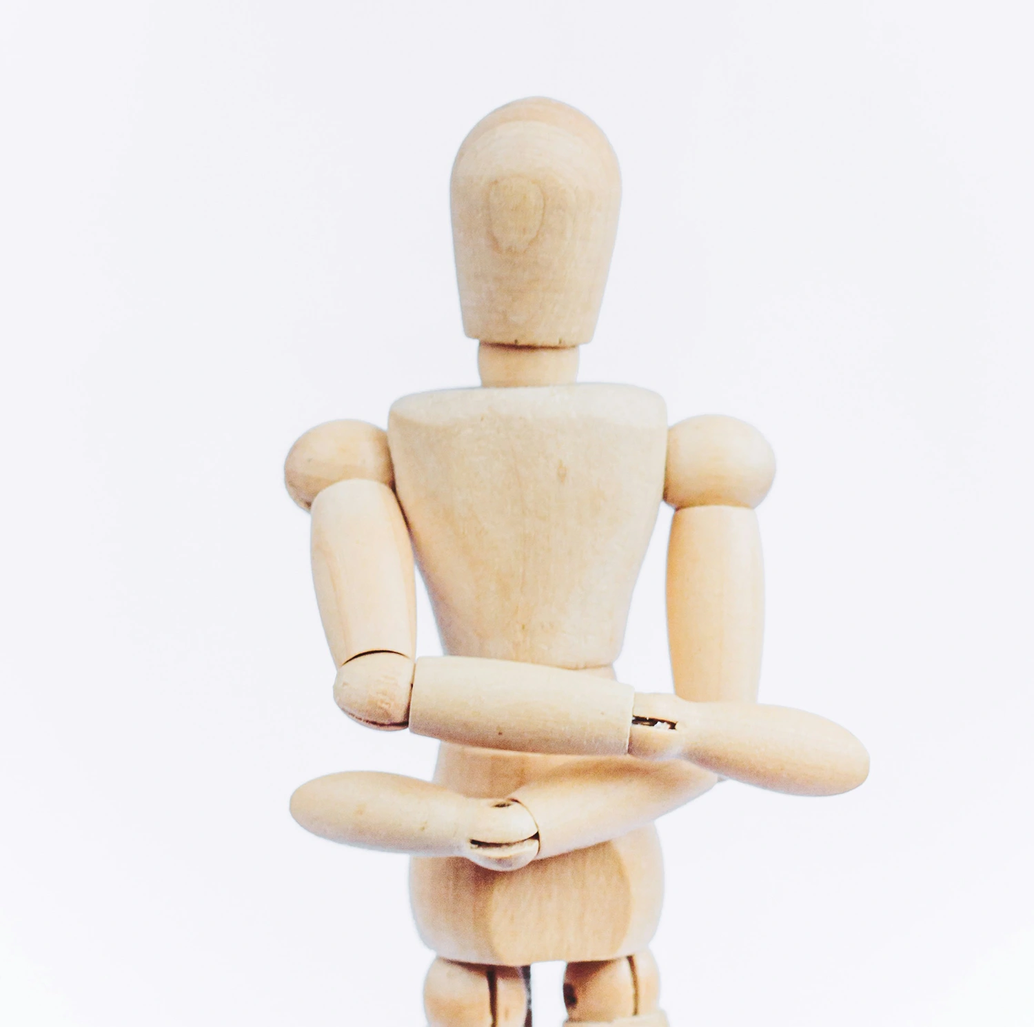 Modern wooden doll in minimalist setting.