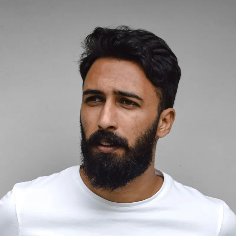 Portrait of a bearded man in white shirt.