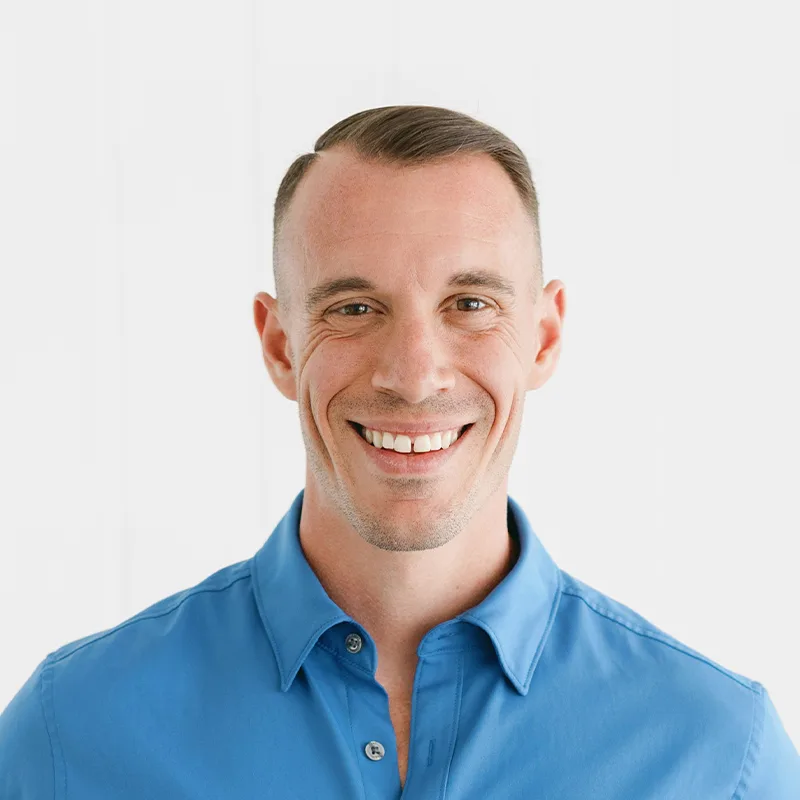 Portrait of a smiling man in a blue shirt.