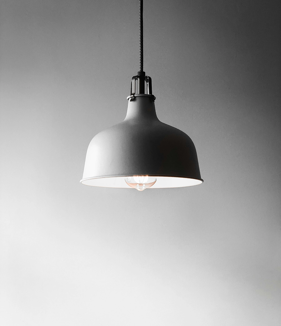 Hanging ceiling lamp with soft lighting against gray background.