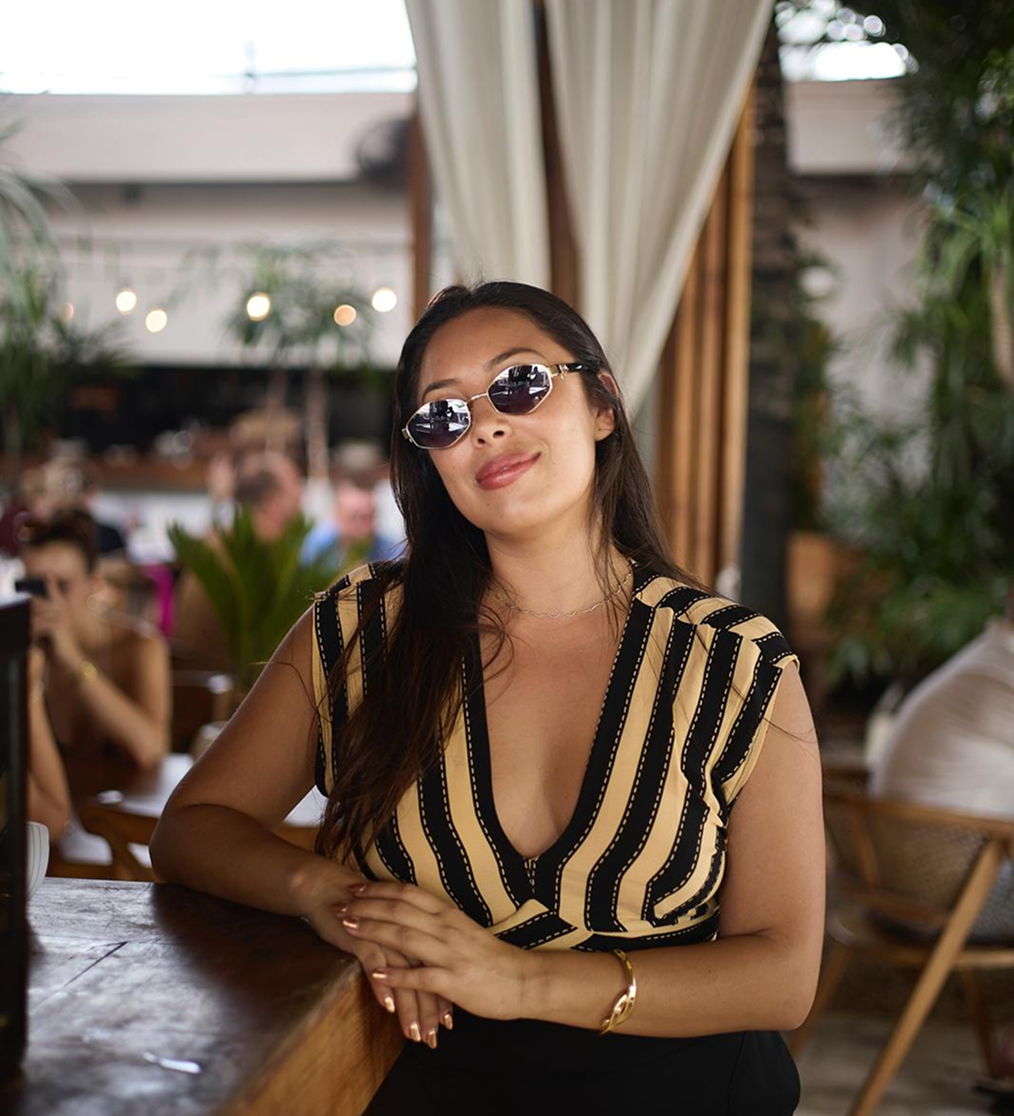 Carla Castro wearing a sunglass with golden and black dress.