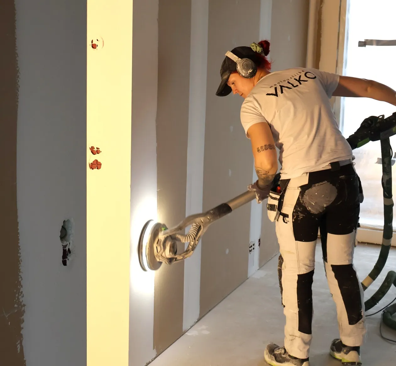 Tasoitetyöntekijä tasoittamassa seinää