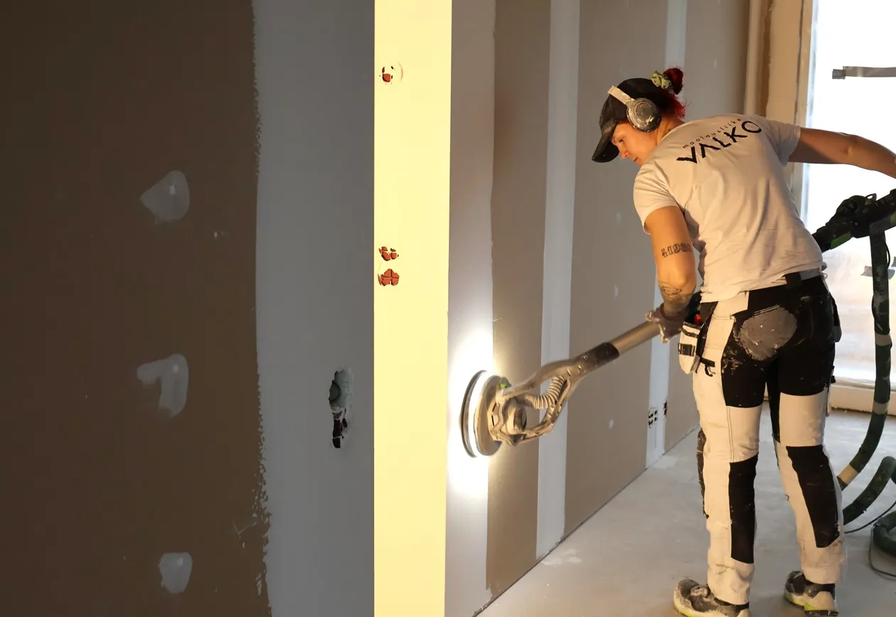 Tasoitetyöntekijä tasoittamassa seinää