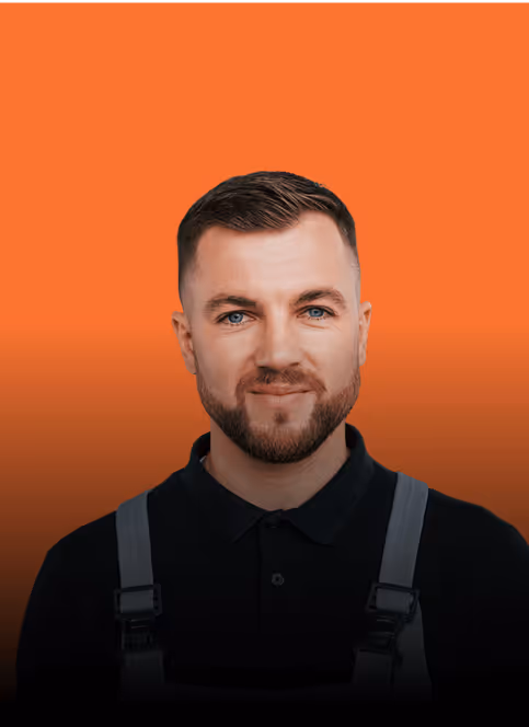 Mann mit Kurzhaarfrisur und Bart in Arbeitskleidung vor orangefarbenem Hintergrund.