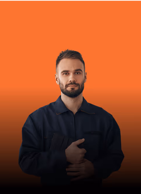 Mann in blauer Arbeitskleidung vor orangefarbenem Hintergrund, hält ein Tablet in der Hand.