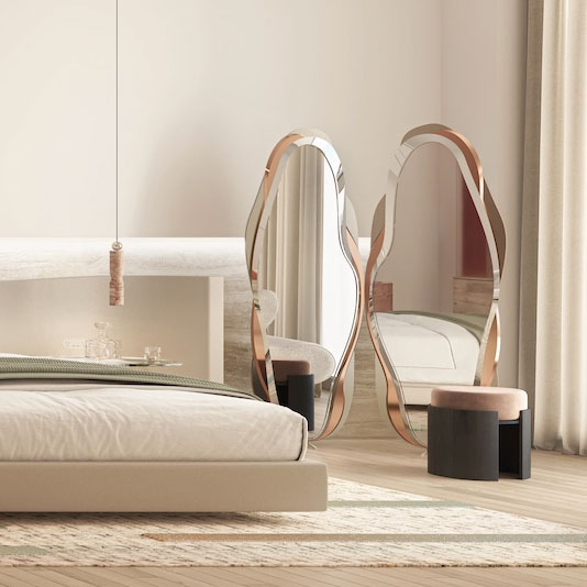 Minimalist luxury bedroom with red travertine open-plan bathroom, curved stone bathtub, neutral tones, and sculptural designer mirrors