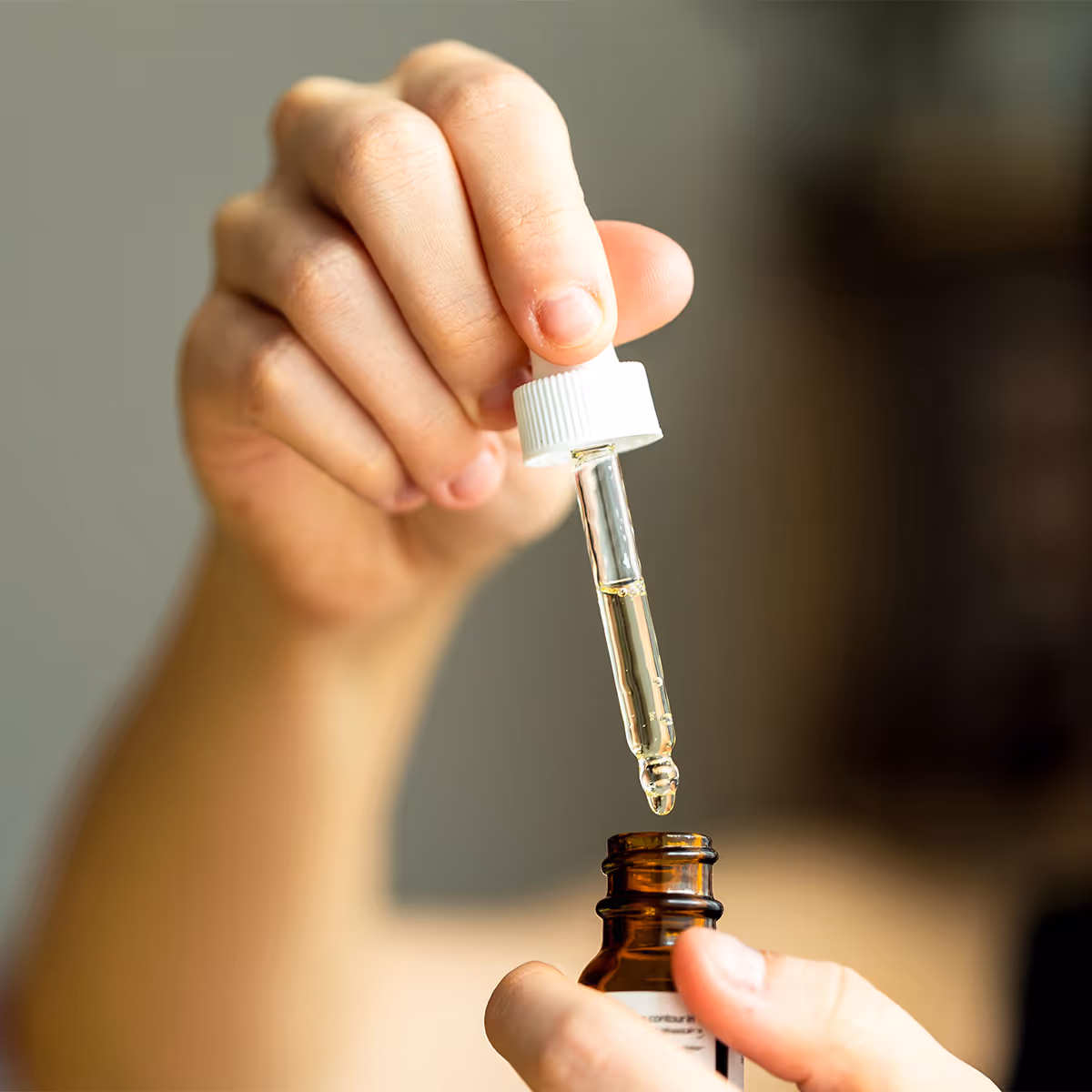 close-up of natural medicine bottle showing pipette holding oil