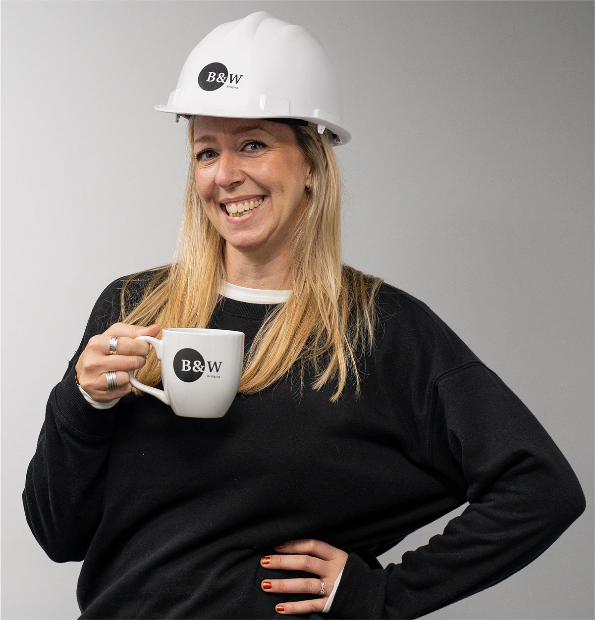 Suze playfully posing with a Black and White Bridging mug, just one of the friendly faces in the company.