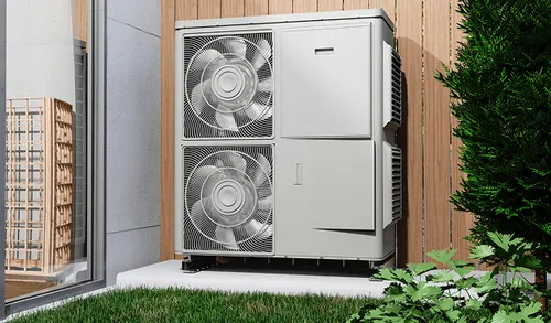 Modern air source heat pump unit installed outside near grass and plants