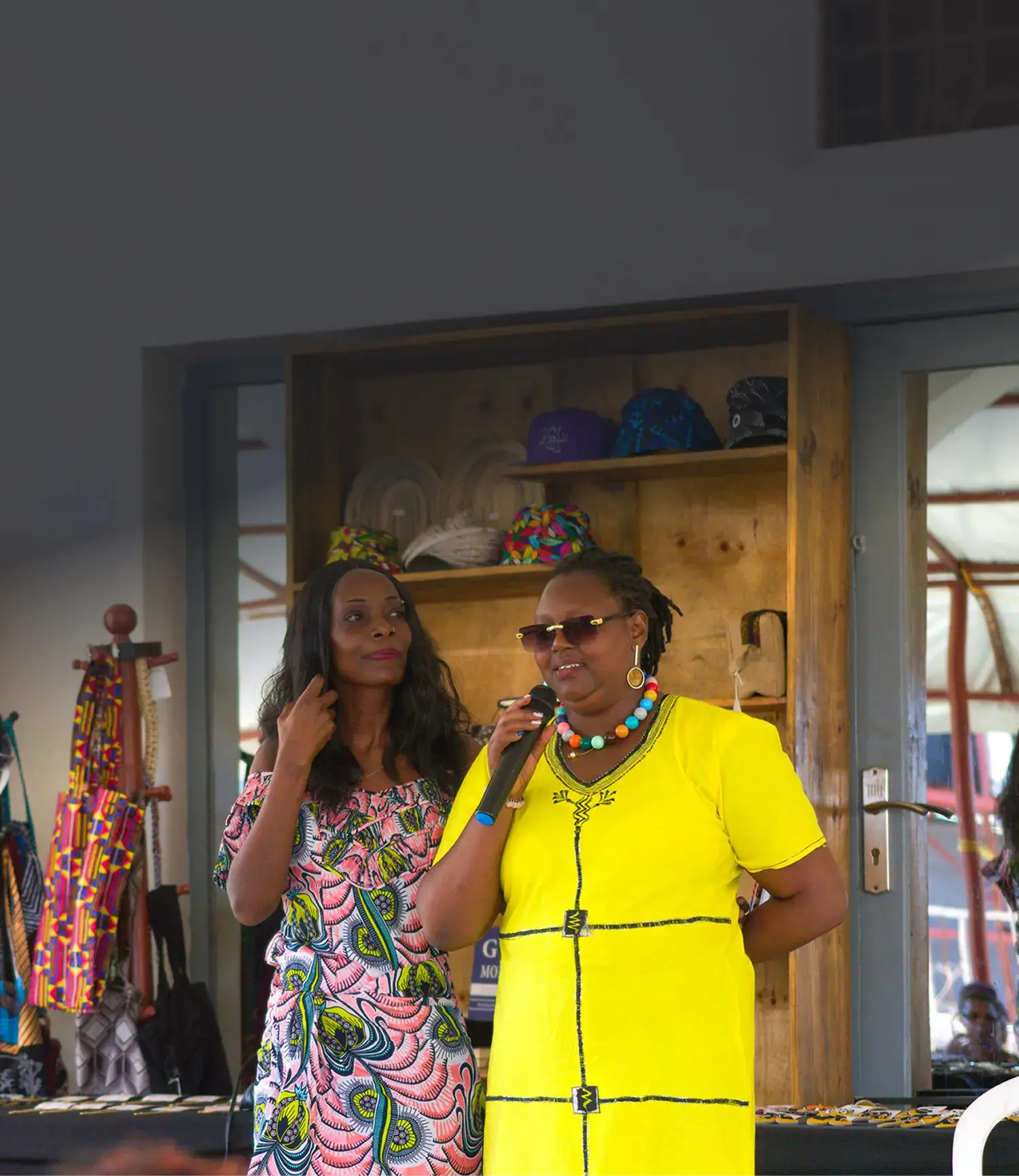 Two women speak confidently at a community event, representing Deriv’s commitment to empowering women through local initiatives.