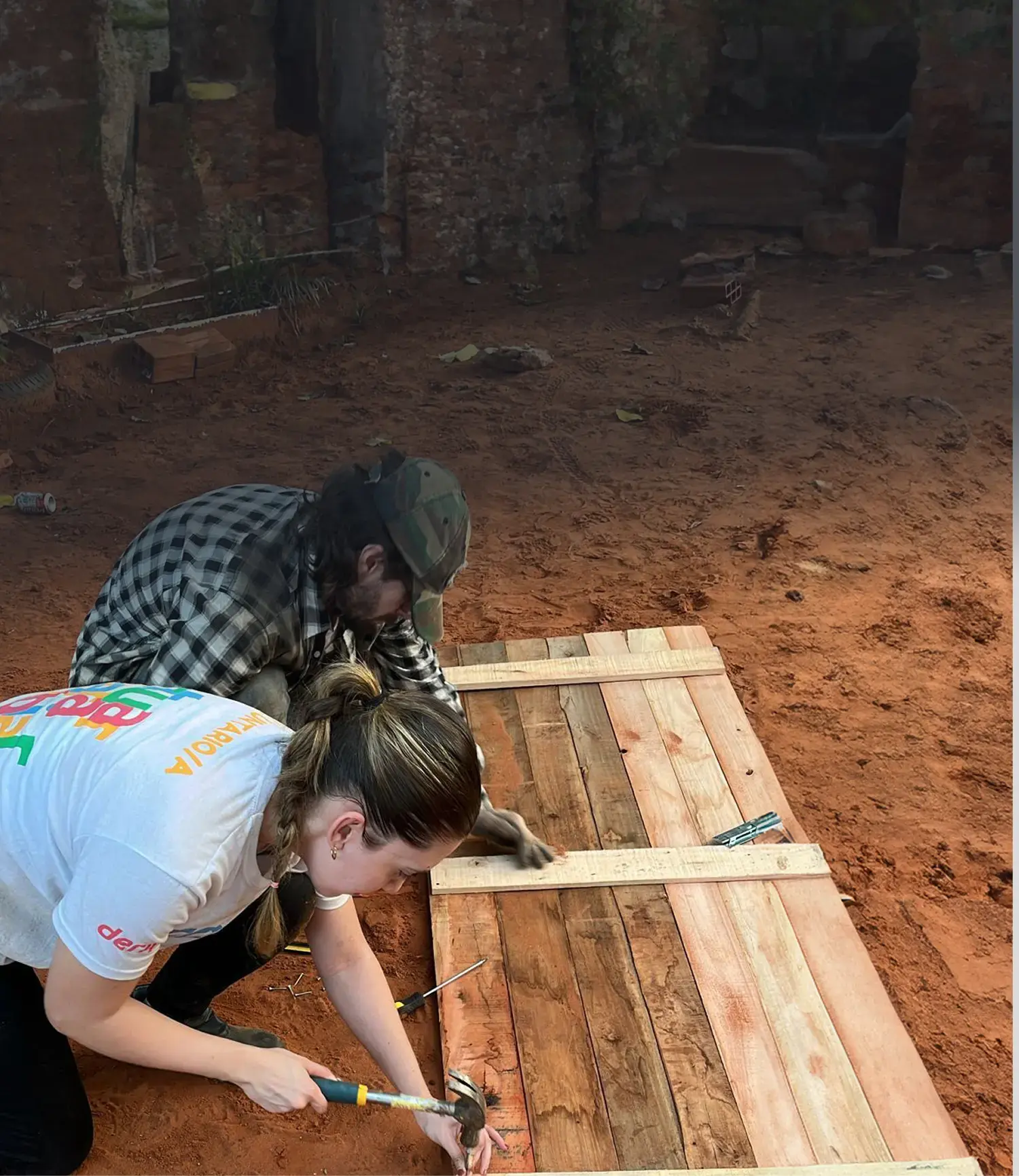 Volunteers building wooden structures together, reflecting Deriv’s hands-on commitment to uplifting and supporting local communities.