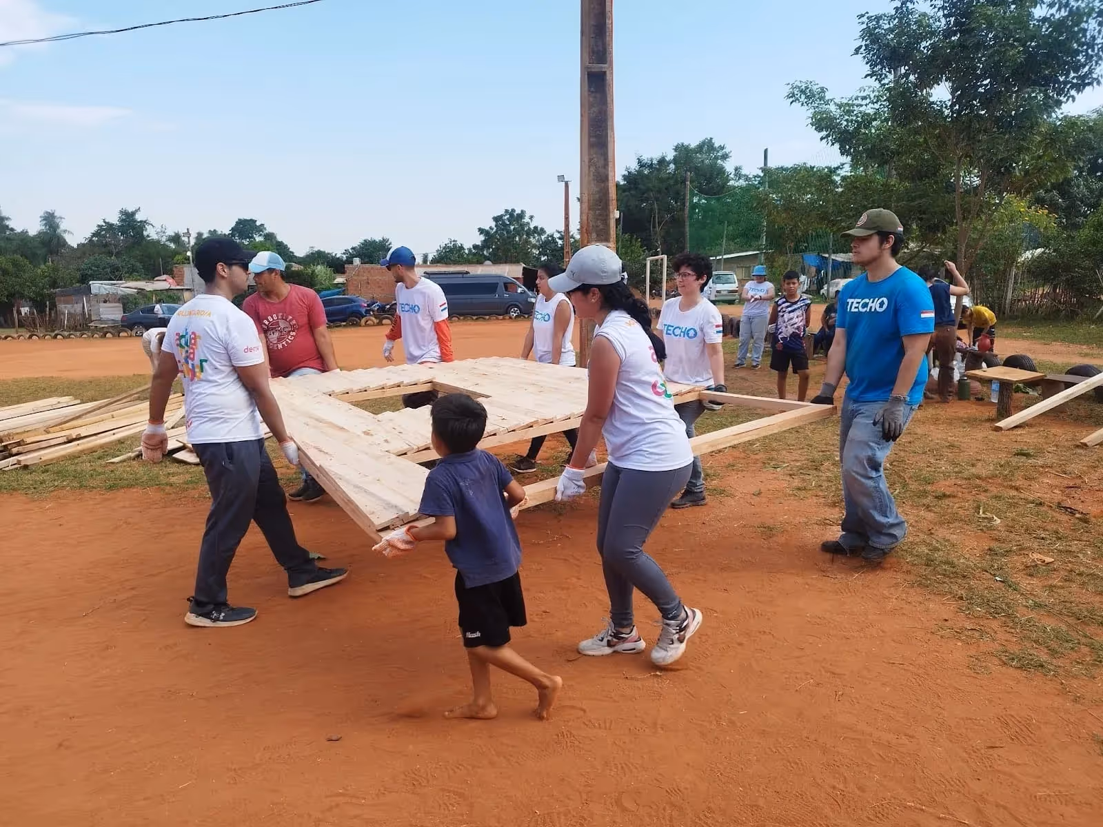 A young boy helping the Deriv Asunción and TECHO employees unloading building materials.