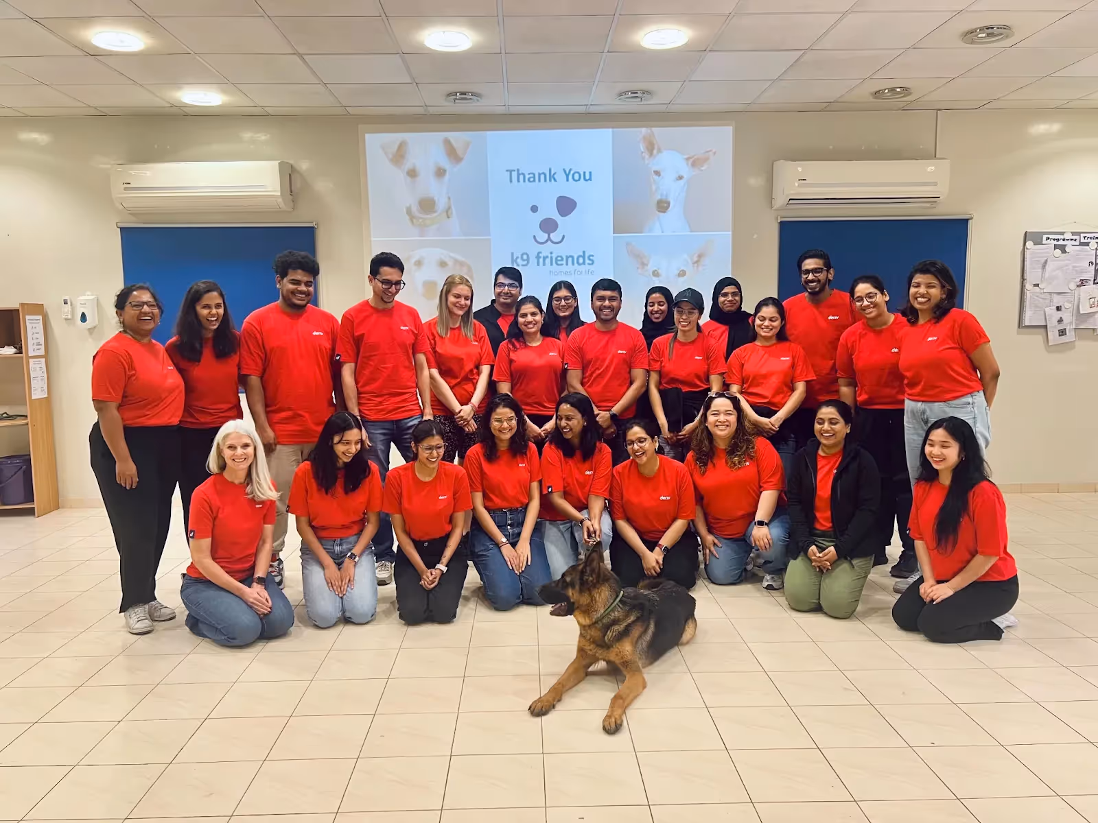 Deriv employees with a dog at K9 Friends NGO, showing their support and participation in the animal shelter initiative.