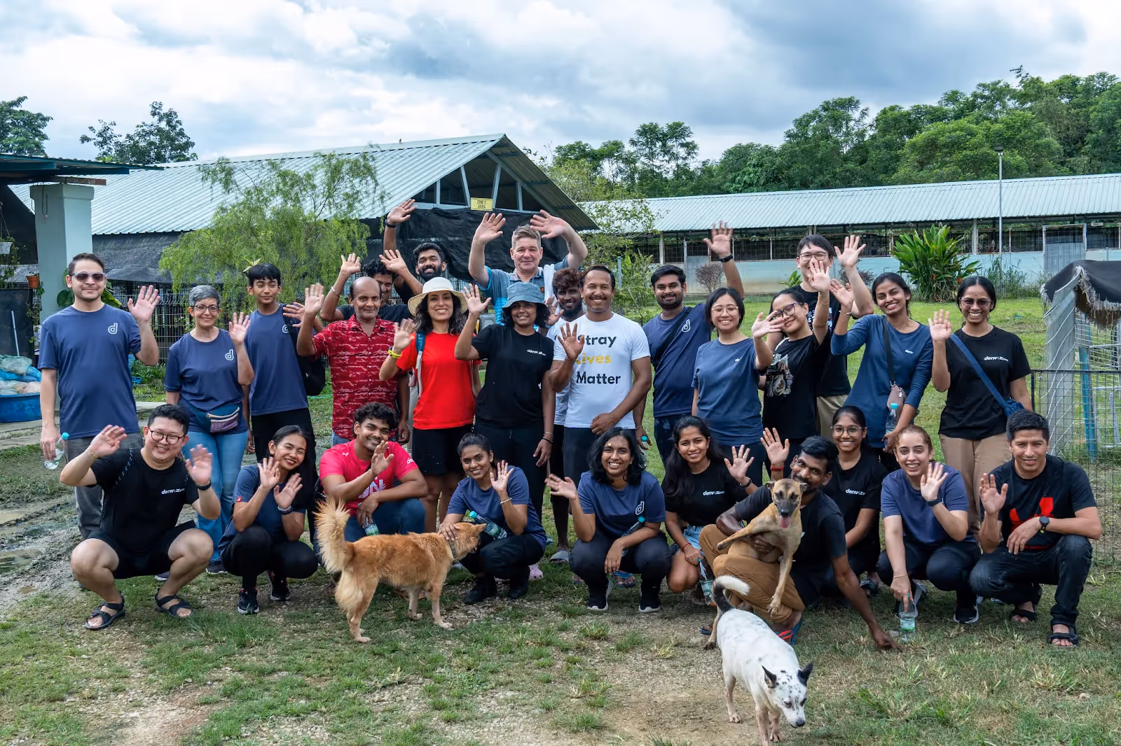 Deriv employees at the Malaysia Independent Animal Rescue (MIAR) with dogs, supporting animal welfare.