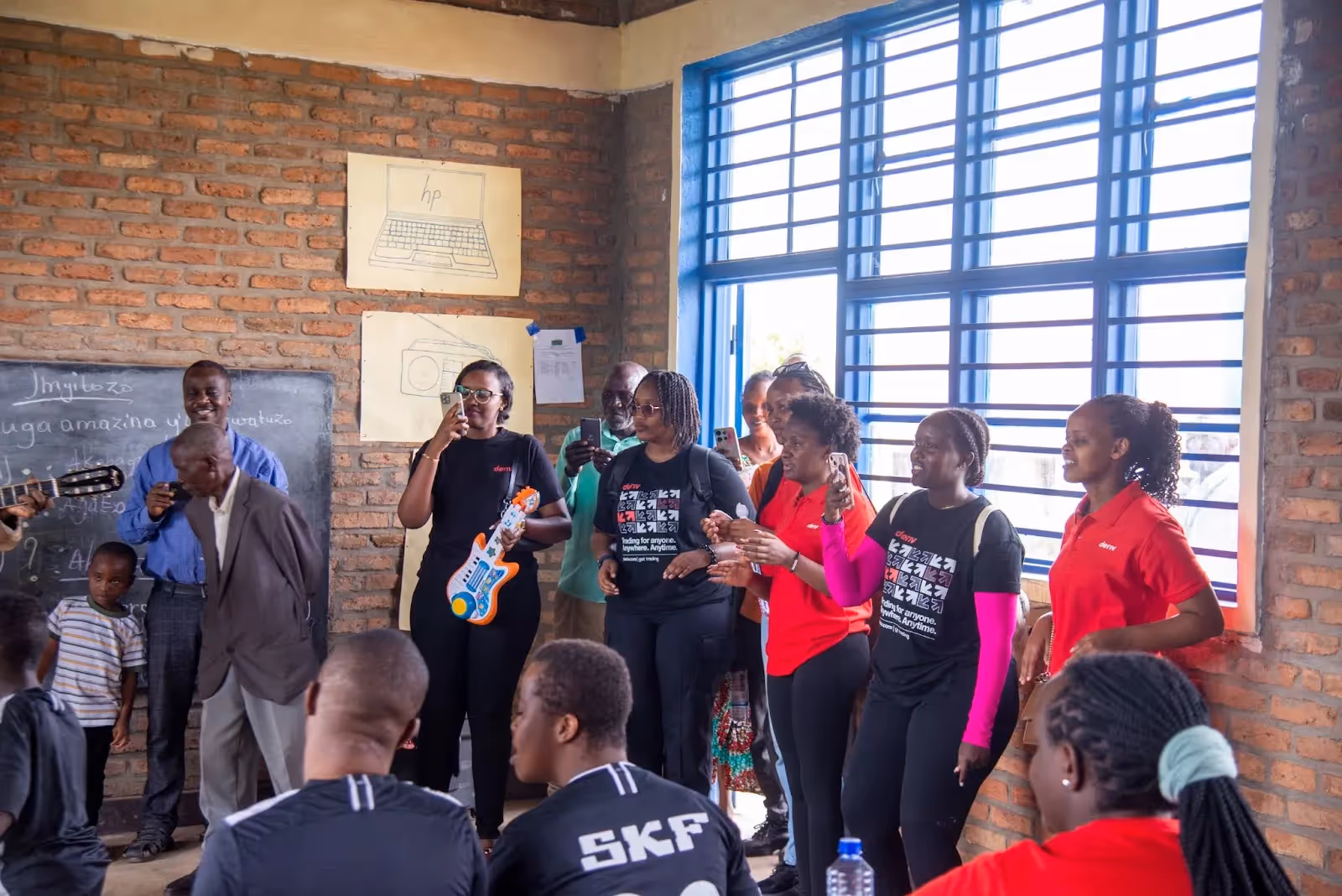 Deriv volunteer joining a rhythmic music session to encourage student self-expression and social engagement.