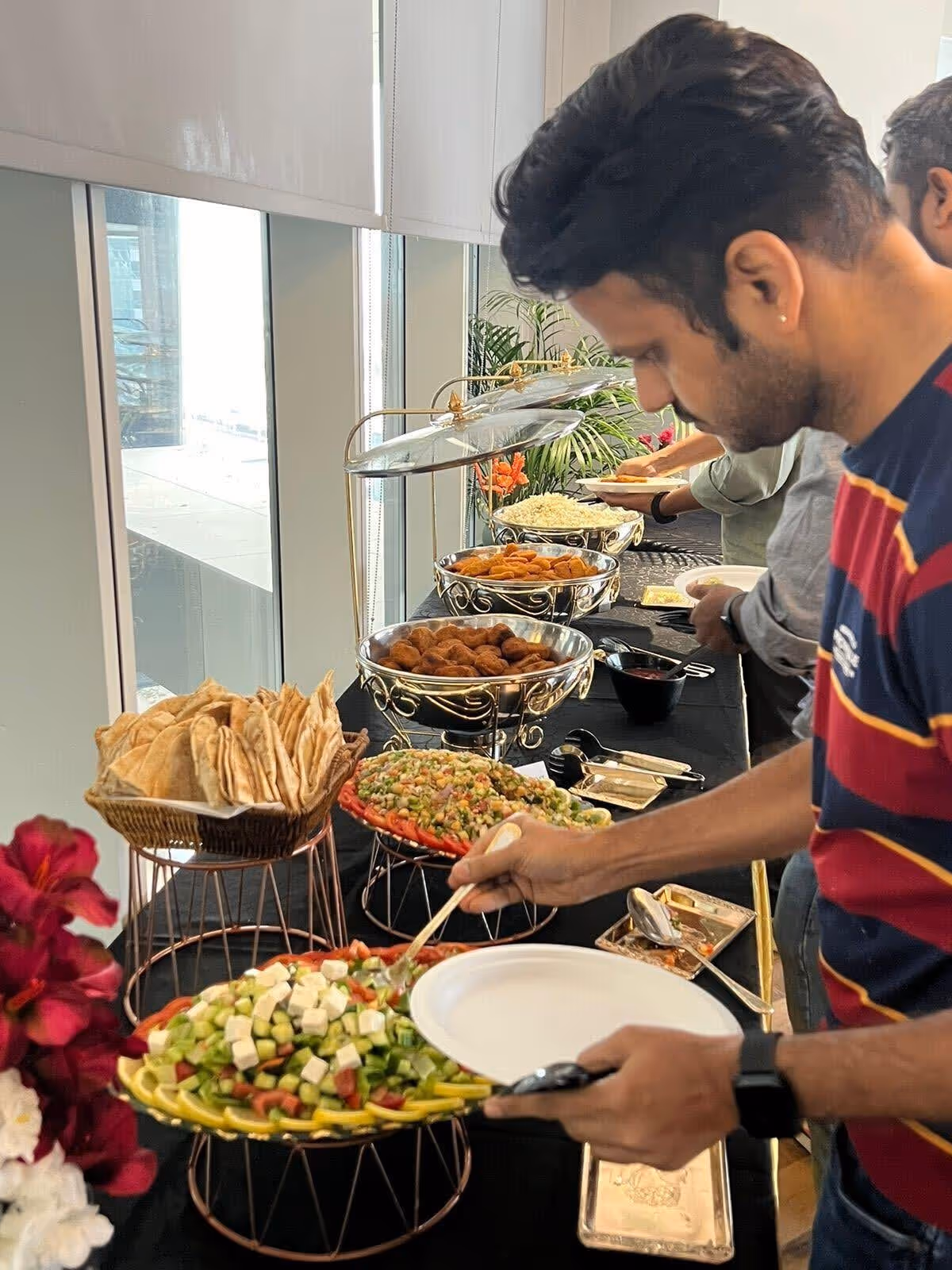 A buffet table featuring various lunch items sponsored by Deriv Dubai for the AWS networking event attendees.