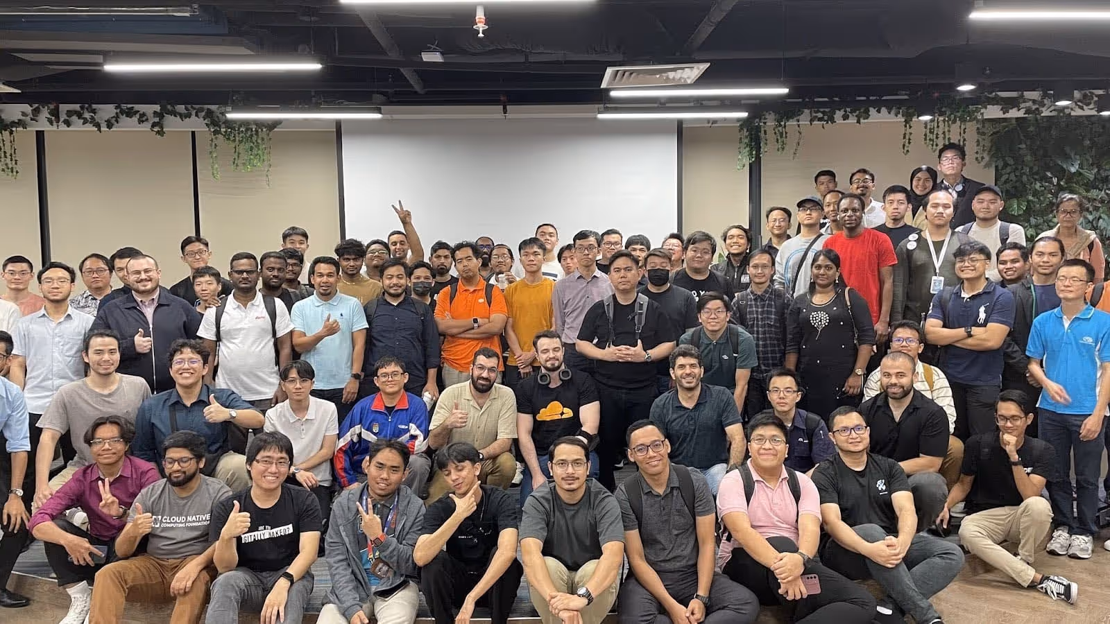 A diverse group of attendees at the Cloud Native Kuala Lumpur Meetup, posing for a group photo.