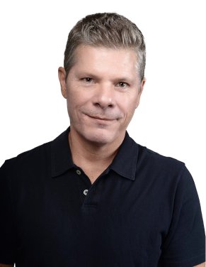 Smiling middle-aged man with short gray hair wearing a black polo shirt against a white background.