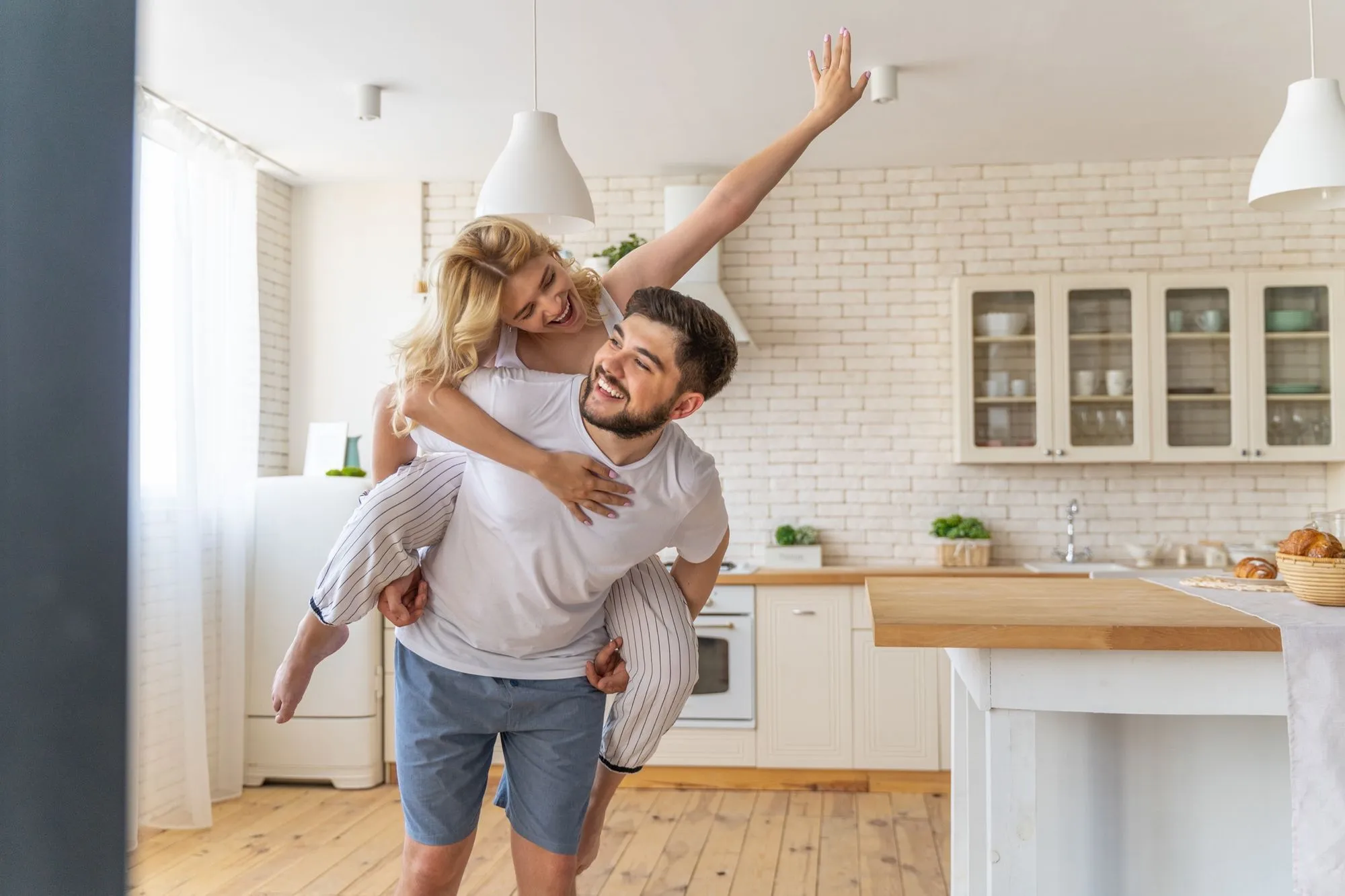 Couple laughing in the kitchen at home