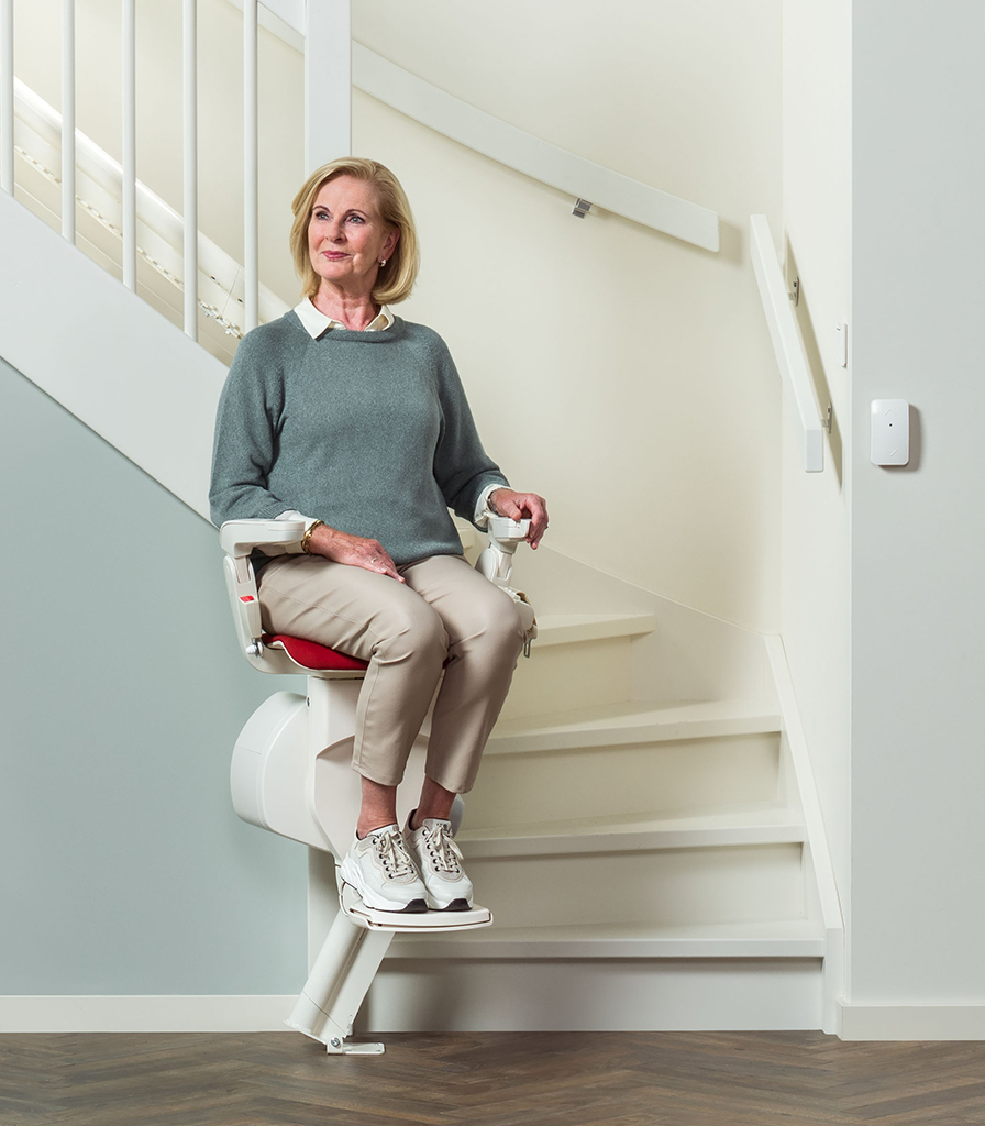 A elderly woman using a stairlift