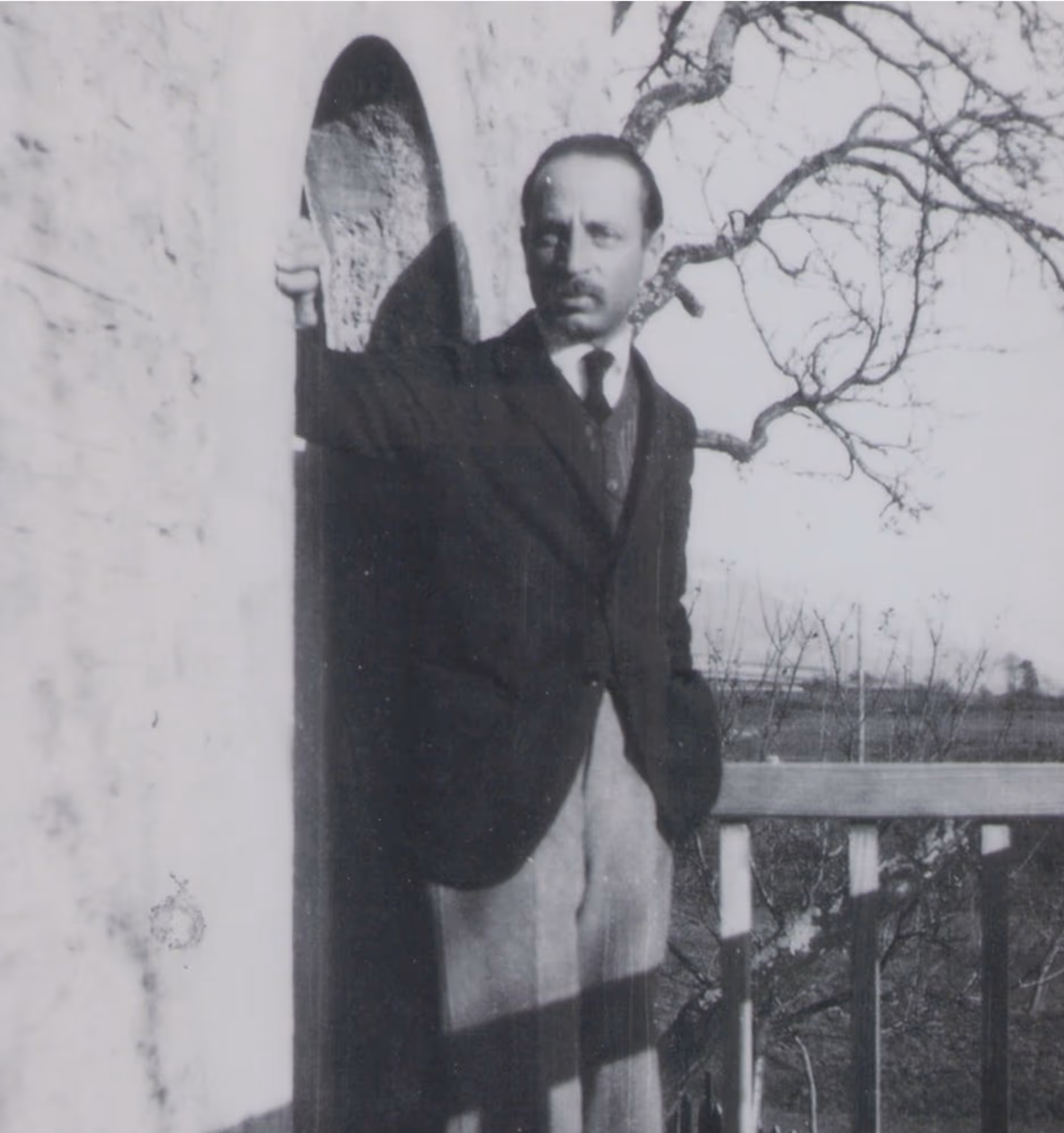 Rainer Maria Rilke stands by the wall of the building.