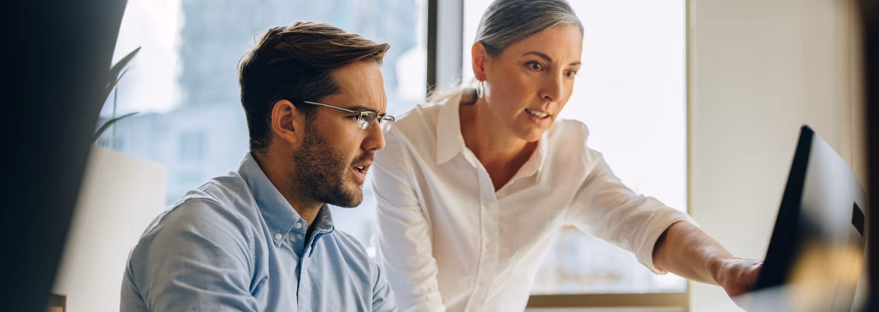 Zwei Berufstätige an einem PC während einer Beratung zu Xurrent von Expertize