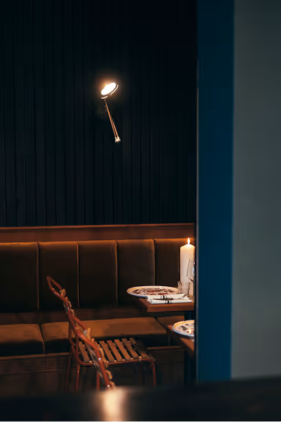 Eckbereich des Italian Shot Glockenbach mit gedecktem Tisch, Weingläsern und warmem Abendlicht.