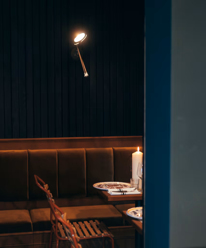 Eckbereich des Italian Shot Glockenbach mit gedecktem Tisch, Weingläsern und warmem Abendlicht.