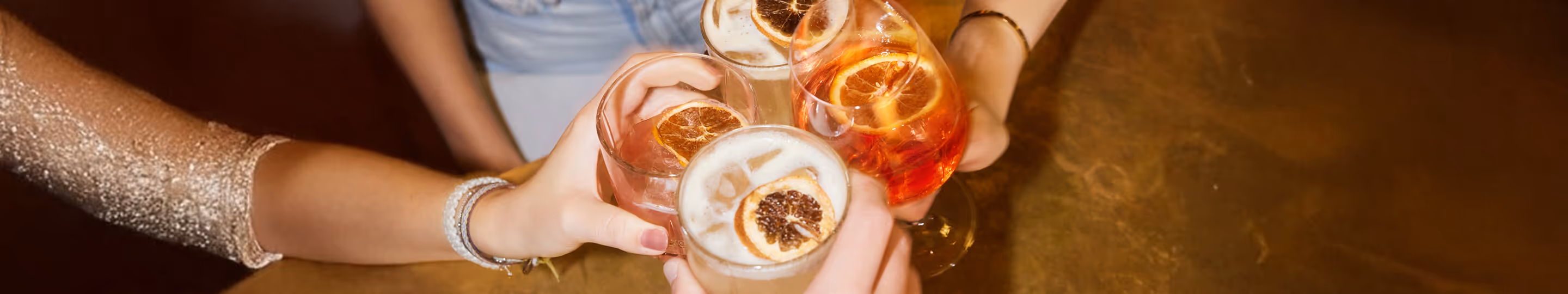 Gäste stoßen im Italian Shot Glockenbach mit verschiedenen Cocktails an, darunter Negroni, Sour und Spritz.