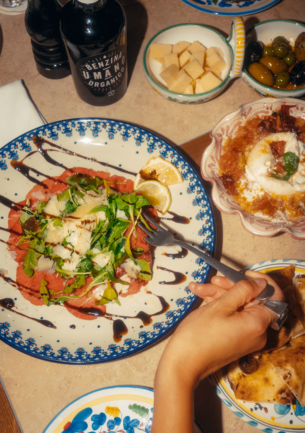 Vorspeisenteller im Italian Shot Glockenbach mit Carpaccio, Burrata und Oliven, aufgenommen aus der Vogelperspektive.