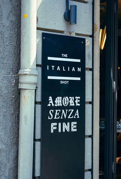 Eingangsschild des Italian Shot Maxvorstadt mit dem Schriftzug „Amore Senza Fine“.