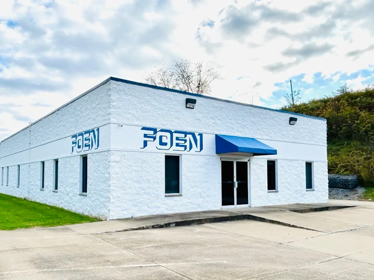 White building with blue awning above the entrance and the inscription FOEN on two sides.