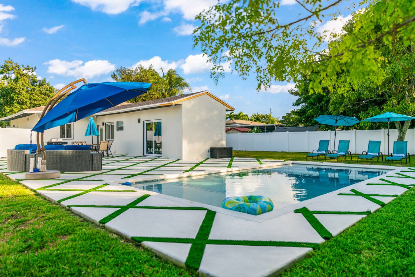 Villa Nomi: heated pool, umbrellas and lounge terrace on a sunny day