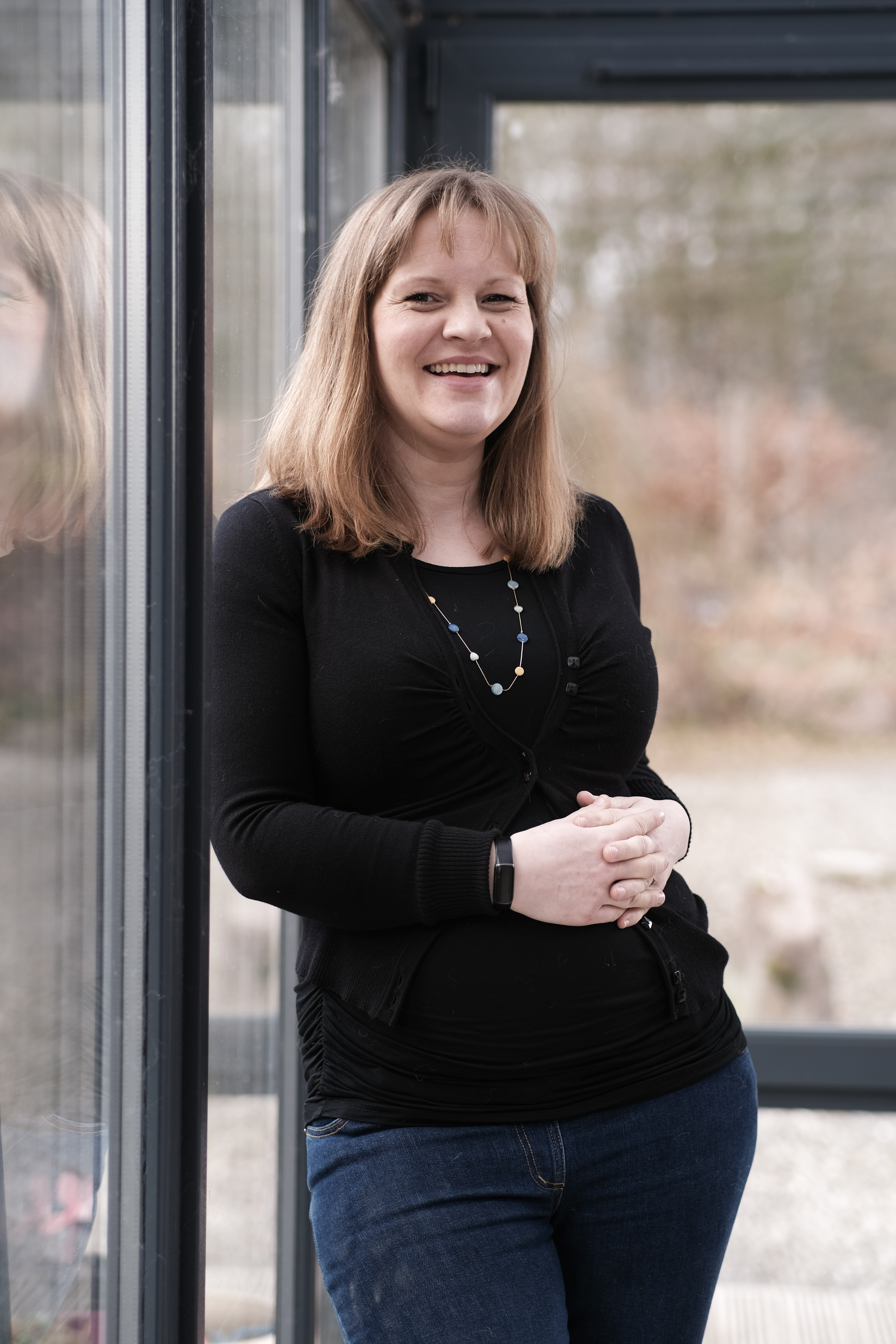 A picture of Rebecca Wilson standing next to window smiling