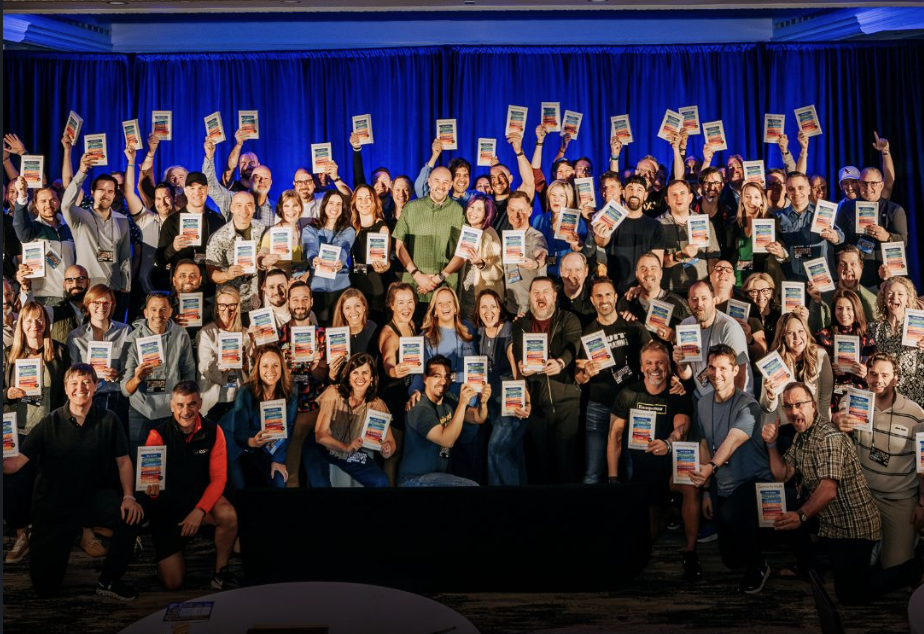 About a hundred supporters holding up copies of Community Made at the launch