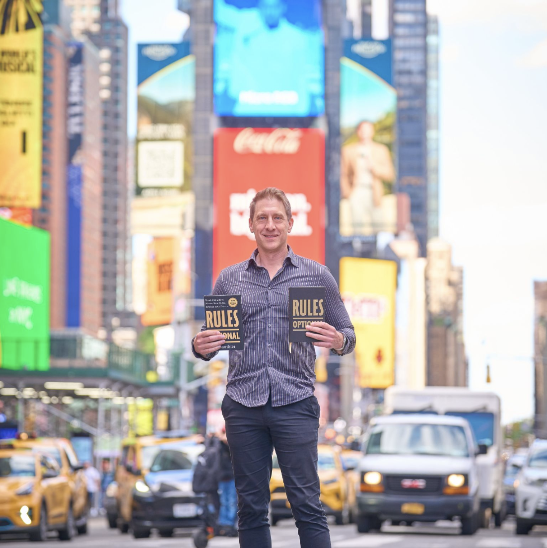 Craig Gauthier holding two copies of Rules: Optional in Times Square