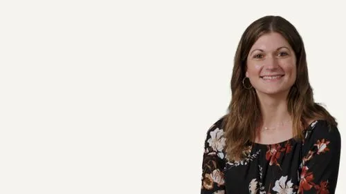 Woman with long brown hair beside KitchenAid logo, a Whirlpool company, product brand representative portrait.