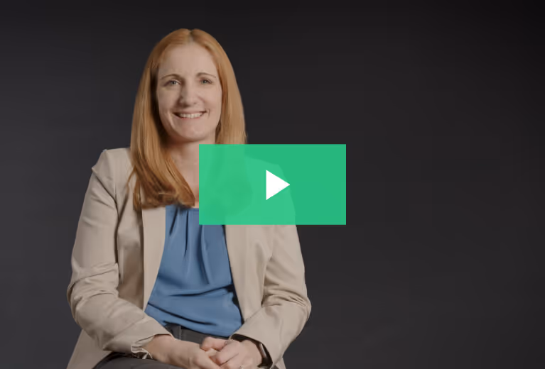 A woman in a blue shirt smiling for the camera.