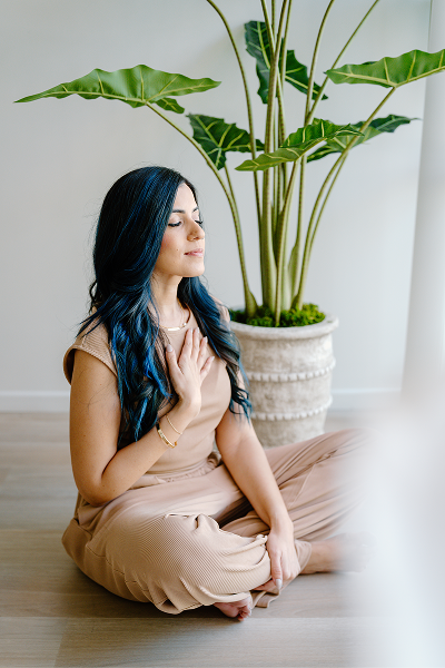 Woman sitting with hand on her chest