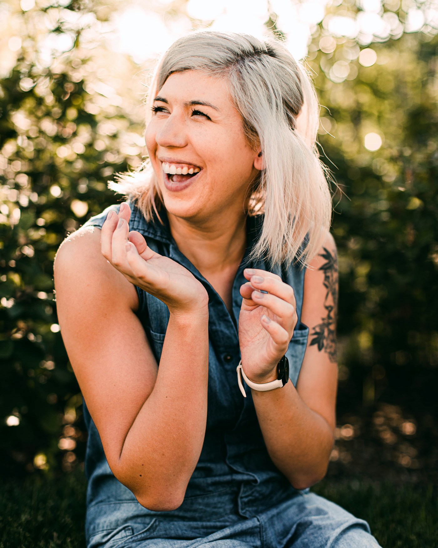 Woman in a black tank top laughing, candid and energised