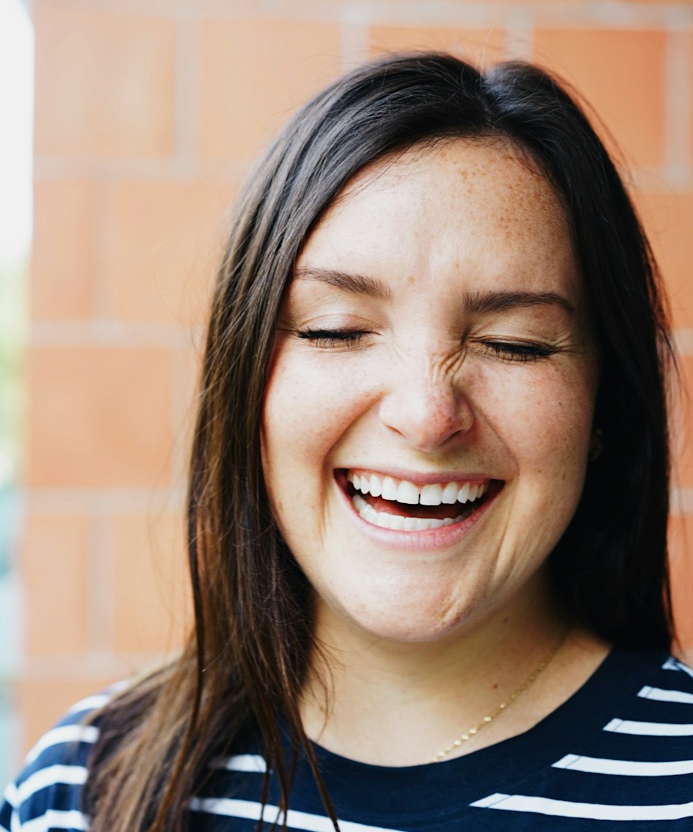 A woman smiling, looking confident and at ease