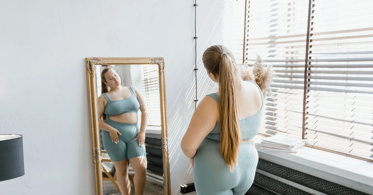 How long does it take for tirzepatide to work? Woman looking at her reflection in a mirror.