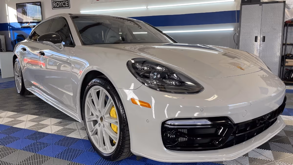 White Porsche Panamera in our Naples detailing studio after ceramic coating—high-gloss paint, yellow calipers, mirror reflections.