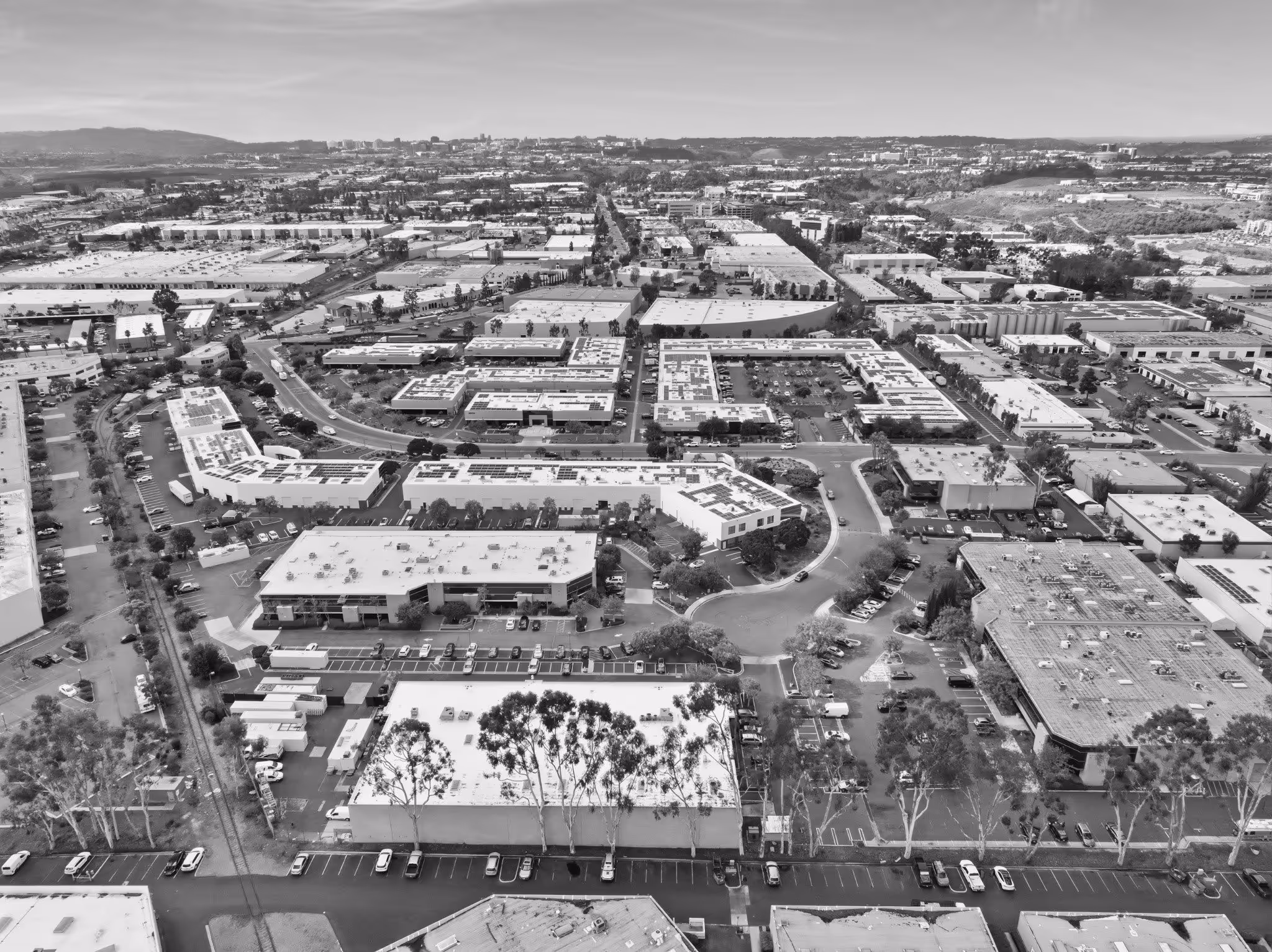 Aerial black and white view of suburban business park with buildings and parking lots