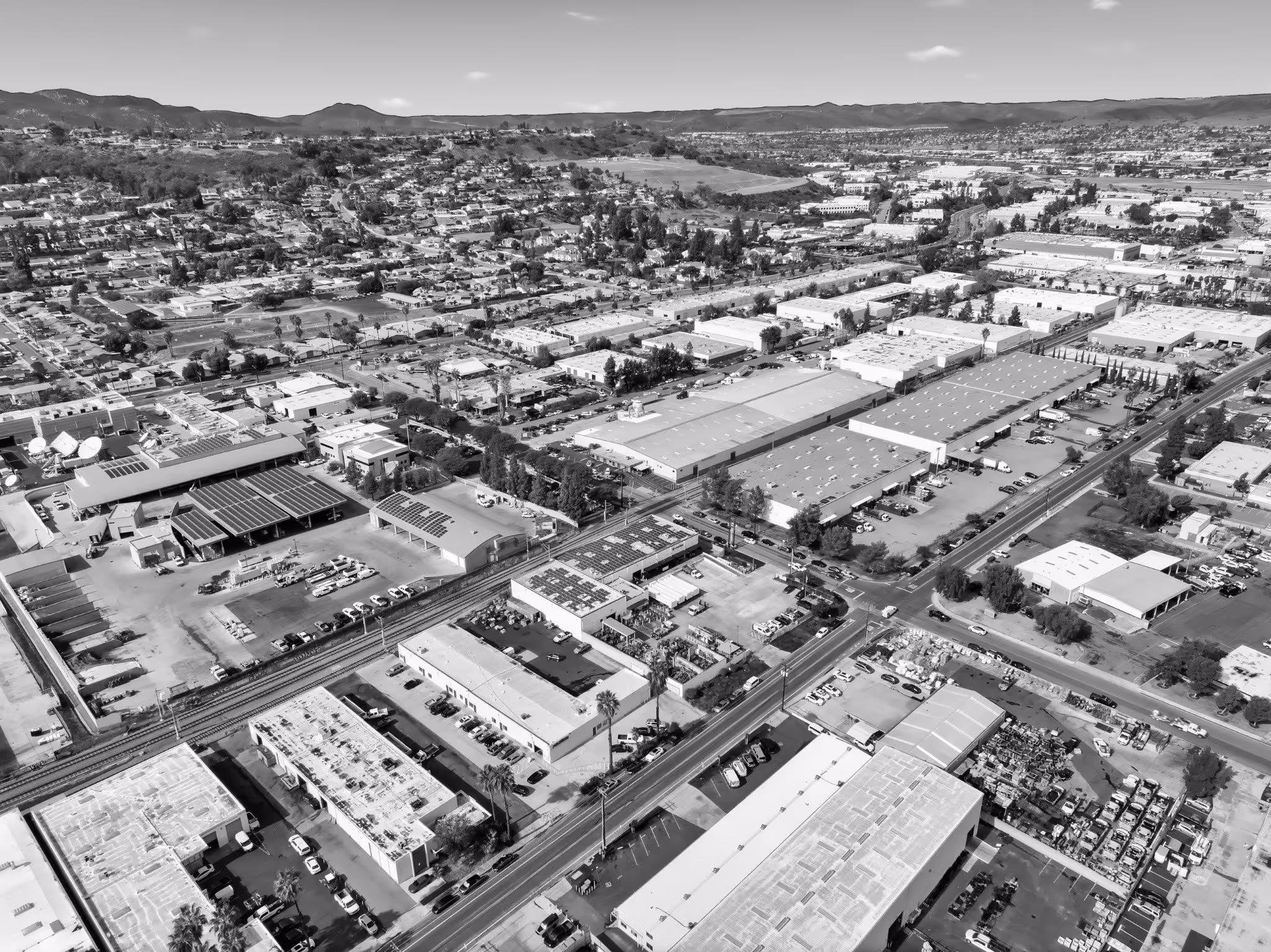 Aerial black and white view of industrial area with buildings and mountains
