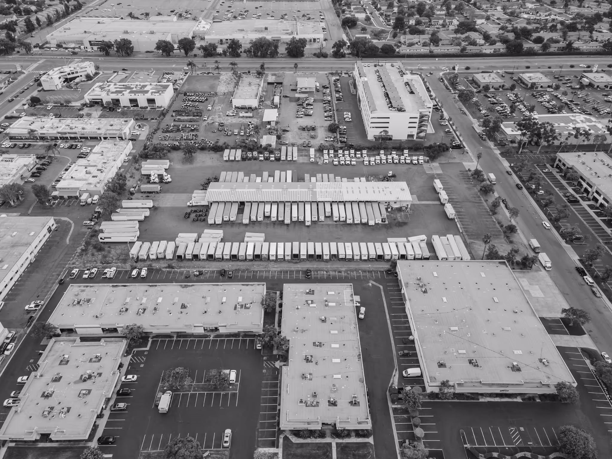 Aerial view of industrial park with warehouses, trucks, and parking lots