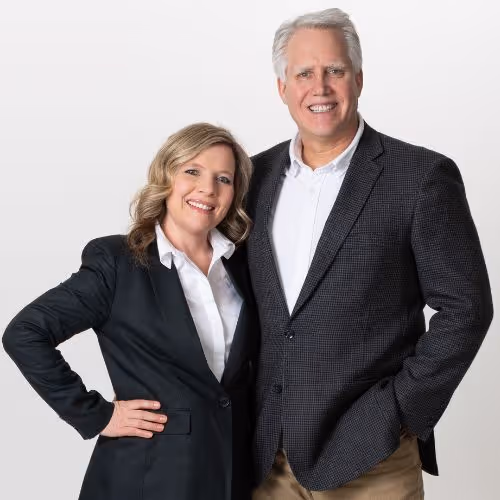 Professional middle-aged couple in business attire posing together