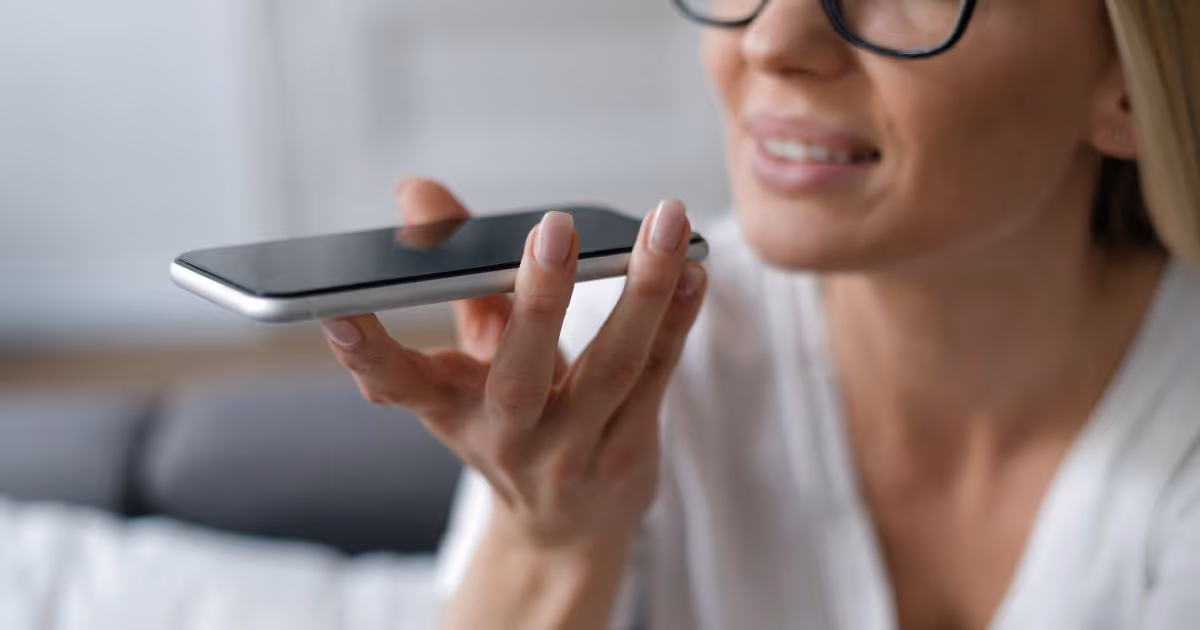 Woman speaking into smartphone with voice recognition or voice command