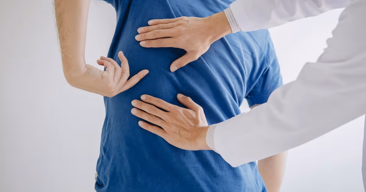 Medical professional examining patient's back during healthcare checkup